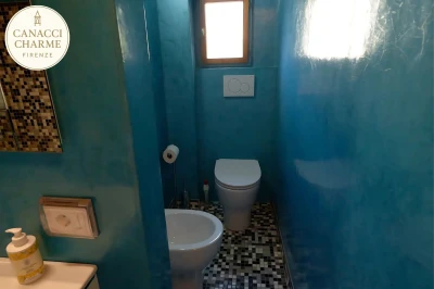 Bagno moderno con pareti turchesi e finestra